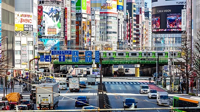 新宿の大ガードを通る電車と、交差点を行き交う車やバス